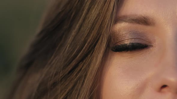 Close-up of Woman's Face Outdoors. Woman's Eye Opening While Looking at Camera.