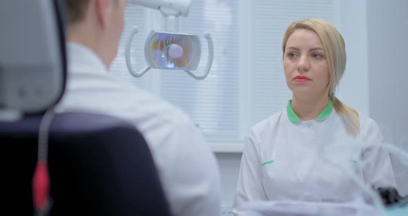 Beautiful Woman Orthodontist Listens to Patient Complaints