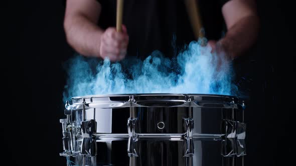 Playing Drums with Colorful Blue Powder Closeup