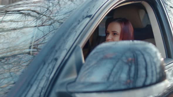 Young Woman Sitting in Car and Talking