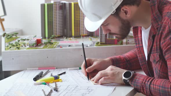 Young Builder Working with Project in Office.