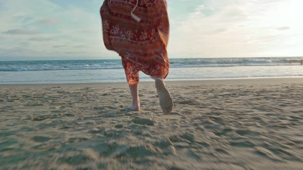 Slow Motion From Behind of Woman As She Runs Towards the Ocean