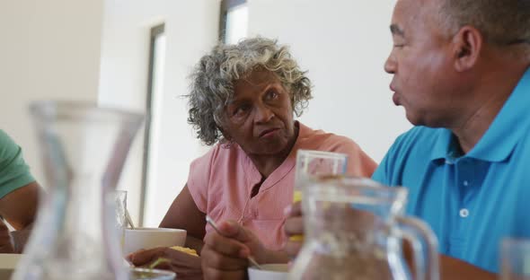 Happy senior diverse people having breakfast at retirement home