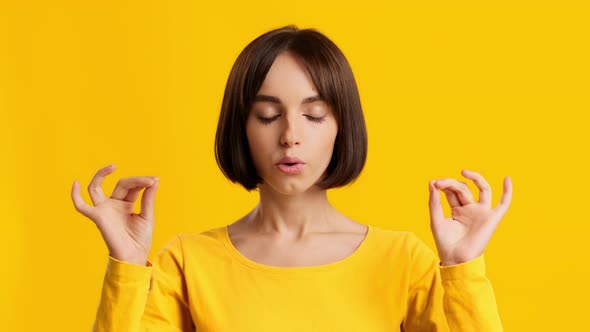 Young Woman Meditating Calming Down Relaxing Posing Over Yellow Background