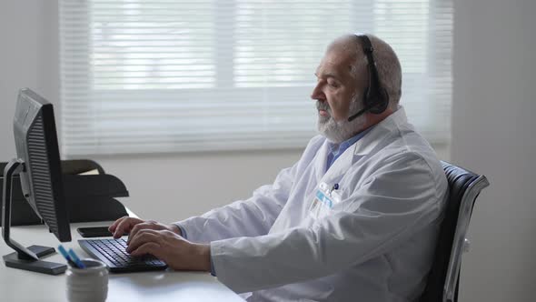 Medicine Technology and Healthcare Concept Senior Male Doctor or Nurse with Headset and Computer