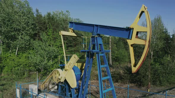 Aerial zoom out away from pumpjack extracting crude oil near Campina, Romania