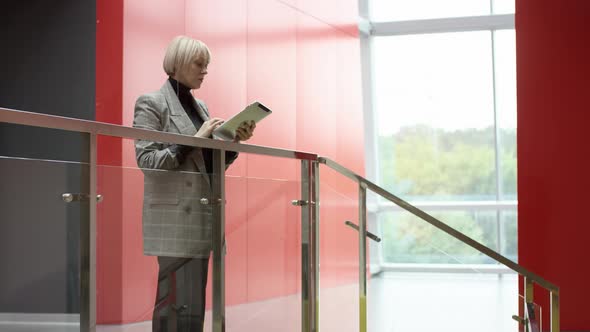 A Side View Slow Motion Close Up Shot of a Blonde Business Woman Standing Inside an Office Centre