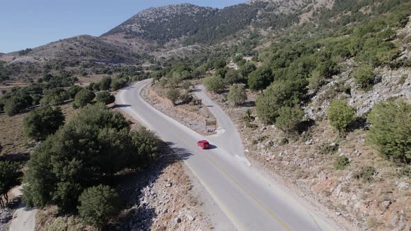 Drone Aerial view red car drive in beautiful mountainous terrain. Small cars driving