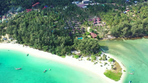 Aerial panorama of the Thailand coast. Malibu beach surrounded by jungle and turquoise water with bo