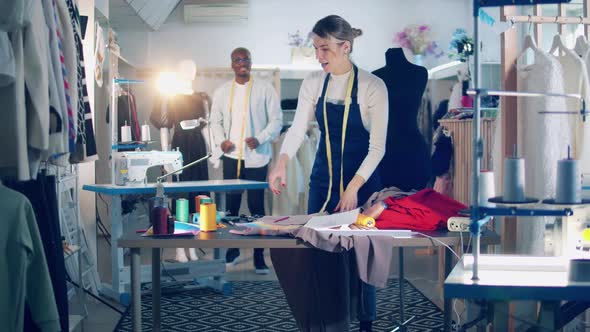 Two Tailors are Working with Fabric in the Workshop