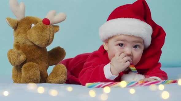 Christmas Portrait of Cute Little Newborn Baby Girl Wearing Santa Hat and Dress Winter Time