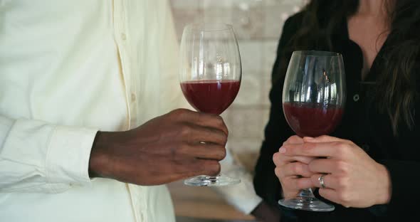 Closeup Glasses of Wine Holding and Talk Young Couple