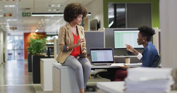 Video of diverse businesswomen working on project and using laptop