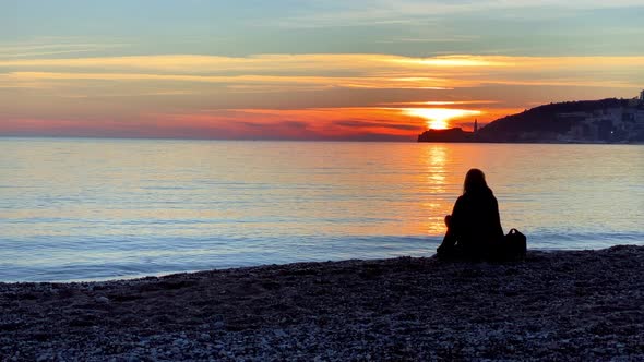 Person Decided to Take a Break During a Walk Put Bag Next to Her and Relax to Sit on Beach and