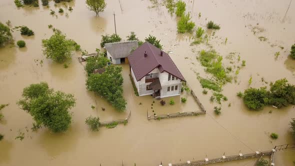 Aerial view of flooded house with dirty water all around it