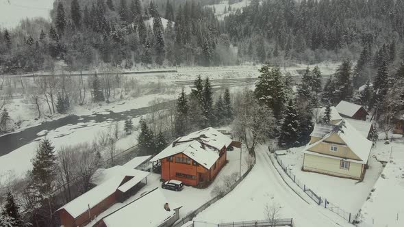 Bird'seye View of Private Houses at the Foot of the Mountain By the River in Winter