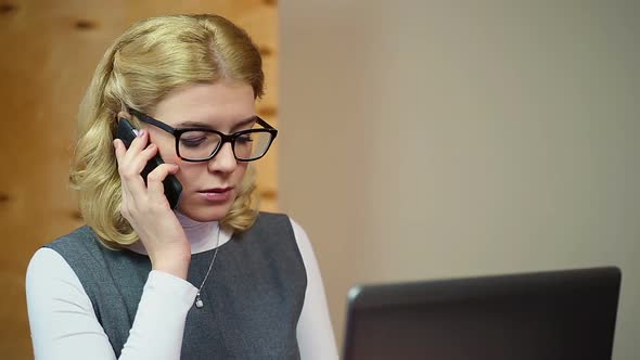 Organized Secretary Answering Calls and Working on Laptop. Office Employee