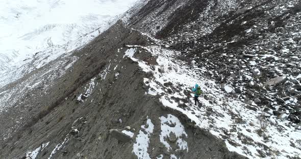 Woman backpacker climbing mountains in winter nature 