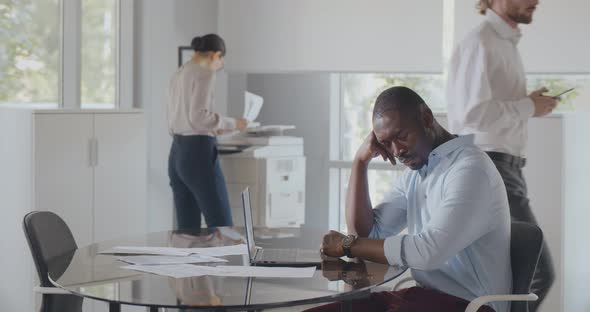 Tired African Businessman Sleeping Sitting at Desk at Workplace