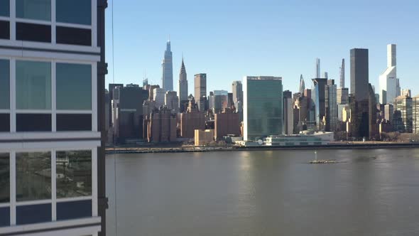 An aerial view from Queens, NY on a sunny day. The drone camera is up close to a new luxury apartmen