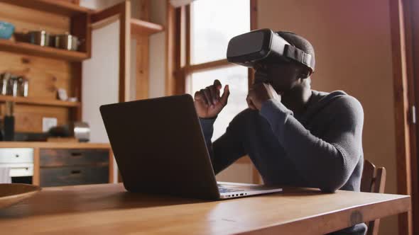 African American man wearing VR headset at home