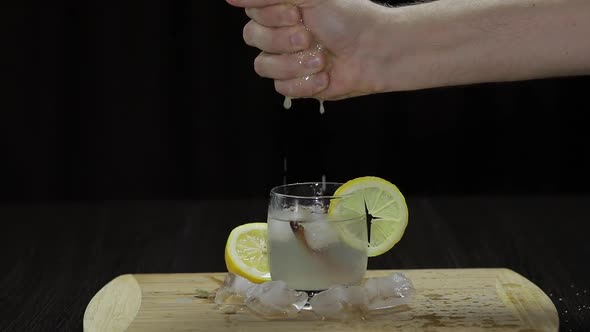 Squeezing Lemon Juice Into a Glass. Fornt View