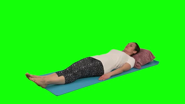 Woman Doing Rehabilitation Exercise While Lying at Mat Raising Leg and Knee Flexed To 90 Against