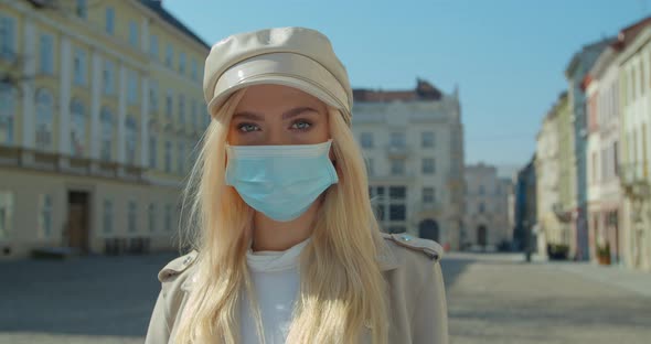 Beautiful Blond Girl Wearing Medical Mask During Coronavirus in the Center of an Empty City COVID-19