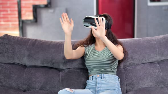 Active Beautiful Young Woman Enjoying Wearing Virtual Reality Helmet Simulator at Home