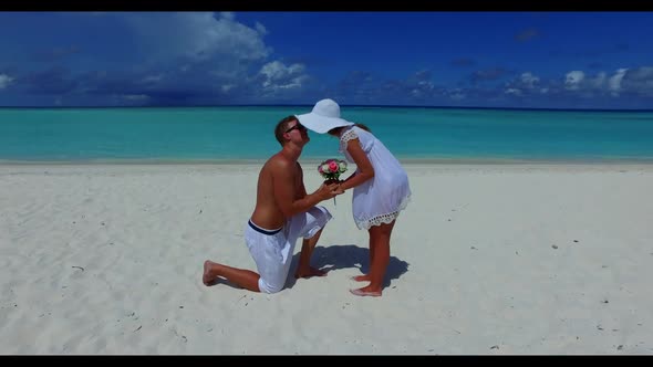 Young couple tanning on relaxing seashore beach wildlife by clear water with white sand background o