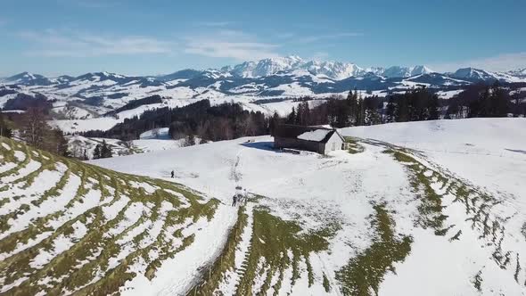 Fast droneshot over a hill and a house in the swiss alps.