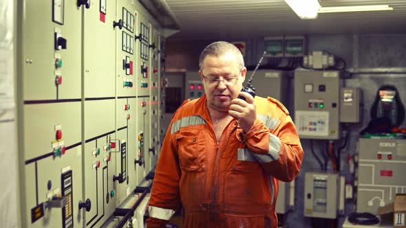 Marine Engineer Working on Radio Communication at Engine Control Room