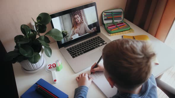 Preschooler Having Video Chat with Teacher Watching Lesson Online and Studying at Home Taking Notes