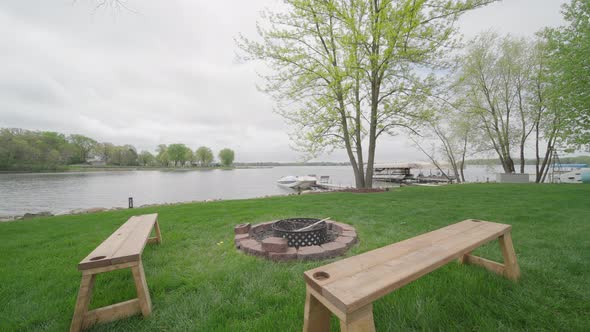 fire pit with benches overlooking a lake with a boat and a dock in northern minnesota