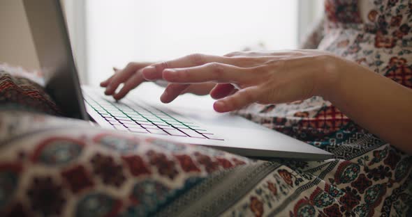 Young woman's hands typing on a laptop