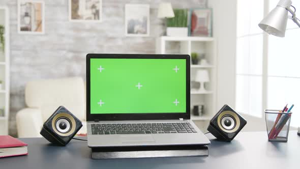 Laptop with Green Screen on the Table in Bright and Well Lit Living Room Space
