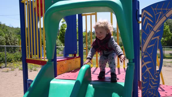 Happy Young Boy Using Playground Slide