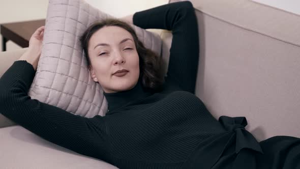 Relaxed Lady is Lying on Couch in Her Cozy Apartment Young Pretty Woman is Resting at Home