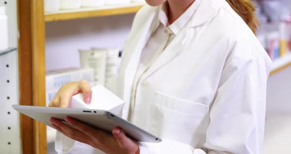Pharmacist using digital tablet while checking medicine