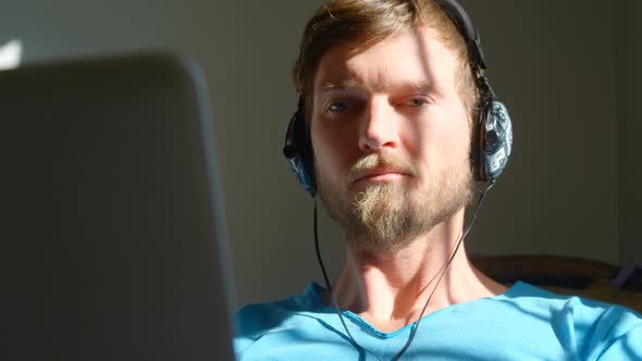 Man using laptop with headphones