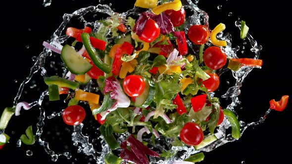 Super Slow Motion Shot of Rotating Exploded Salad and Splashing Water on Black at 1000Fps