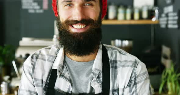 Portrait of waiter standing with arms crossed