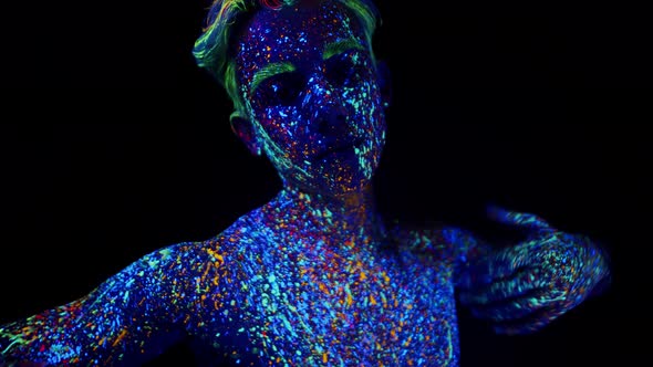 Young Man Painted with Fluorescent Paint is Dancing