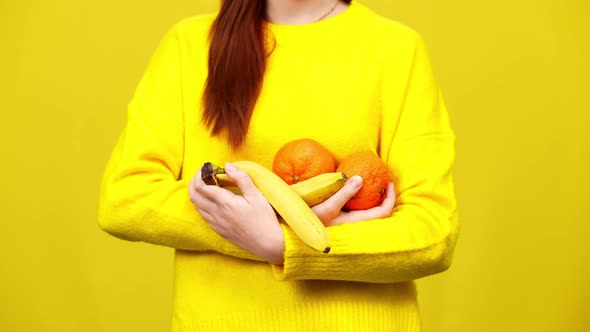 Unrecognizable Woman Holding Healthful Dietary Fruits Posing at Yellow Background