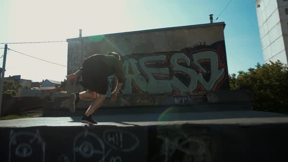 Young parker freerunner runs on the roofs of garages and does somersaults