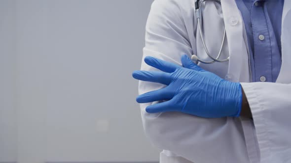 Midsection of male doctor wearing surgical gloves