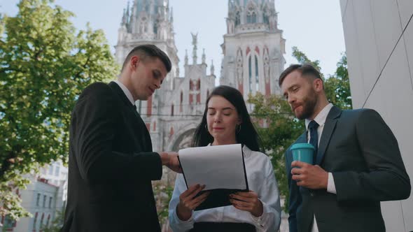 Group of Young Business People Discuss Startups and Sales Growth on the Street Near the Office