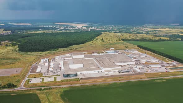 Aerial view of modern industrial building surrounded by green fields