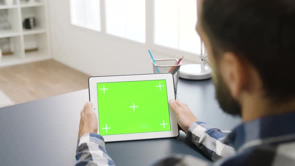 Man Touching the Green Screen of a Digital Table PC