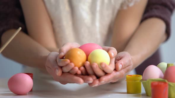 Daughter and Mother Hands Holding Colorful Eggs Together, Easter Holiday, Art